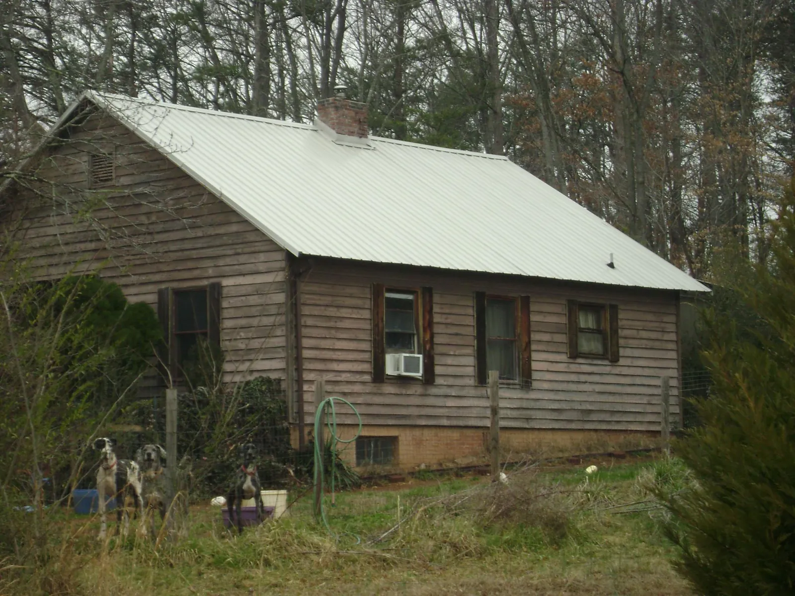 White metal roof on an old wood sided farmhouse, from a Metal Roof Installation job in Spring Lake